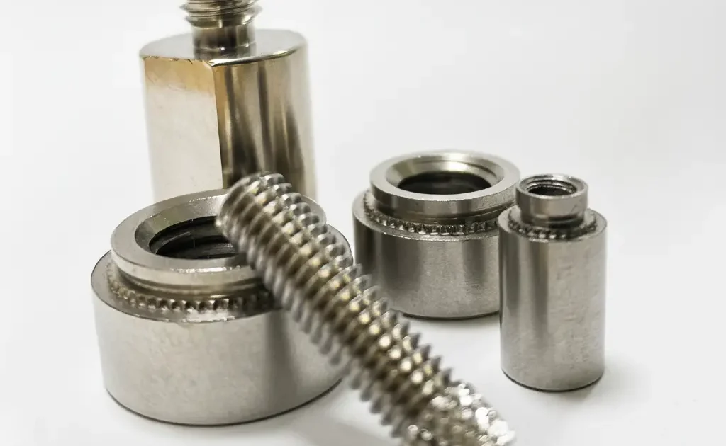 不鏽鋼螺絲與牙條加壓鉚釘組件的近拍展示，展現精密螺紋與五金件結構。