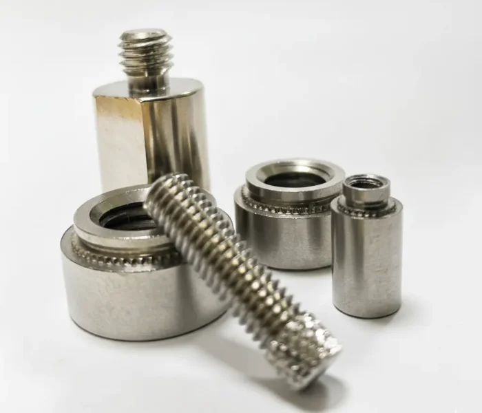 不鏽鋼螺絲與牙條加壓鉚釘組件的近拍展示，展現精密螺紋與五金件結構。